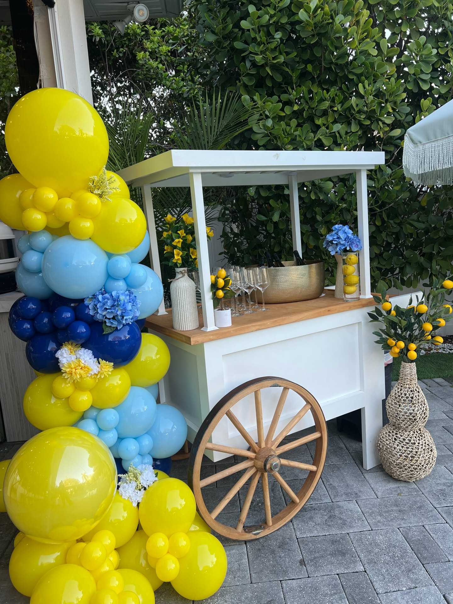 Yellow and blue balloon installation beside a styled beverage cart